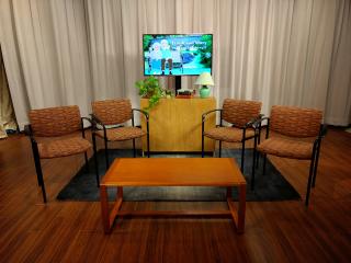 View of NCAT Talk Show Set with curtain backdrop, chairs and monitor for graphics